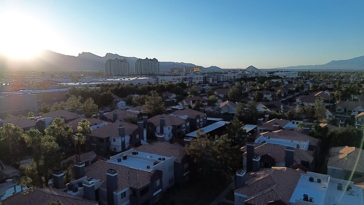 Golden hour aerial of Las Vegas community with mountain backdrop