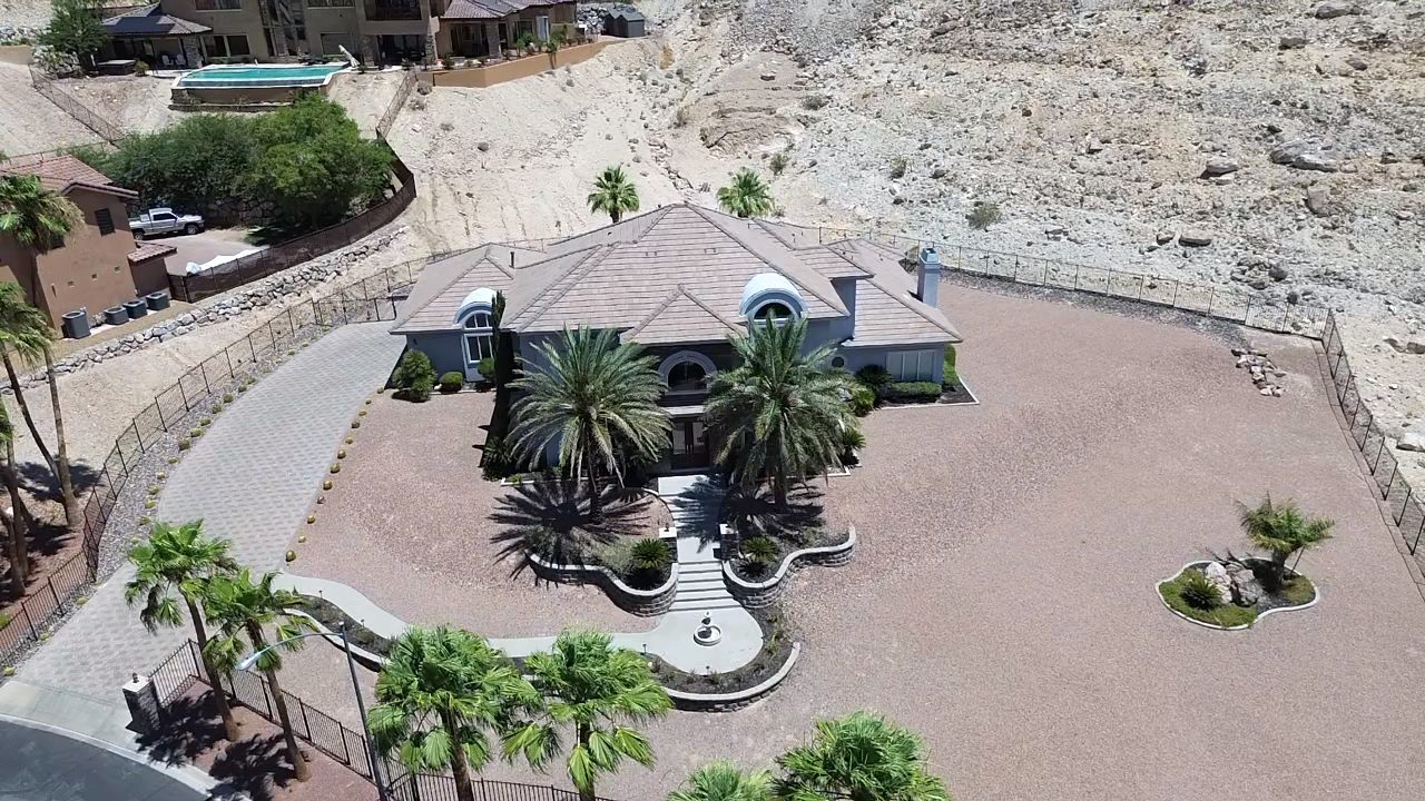Aerial drone photo of luxury Las Vegas estate with circular drive and mountain backdrop