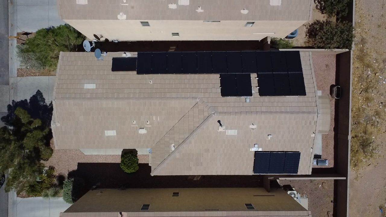 Angled aerial view of residential solar panels against blue sky